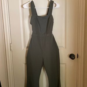 Green flared jumpsuit with open back and self tie.